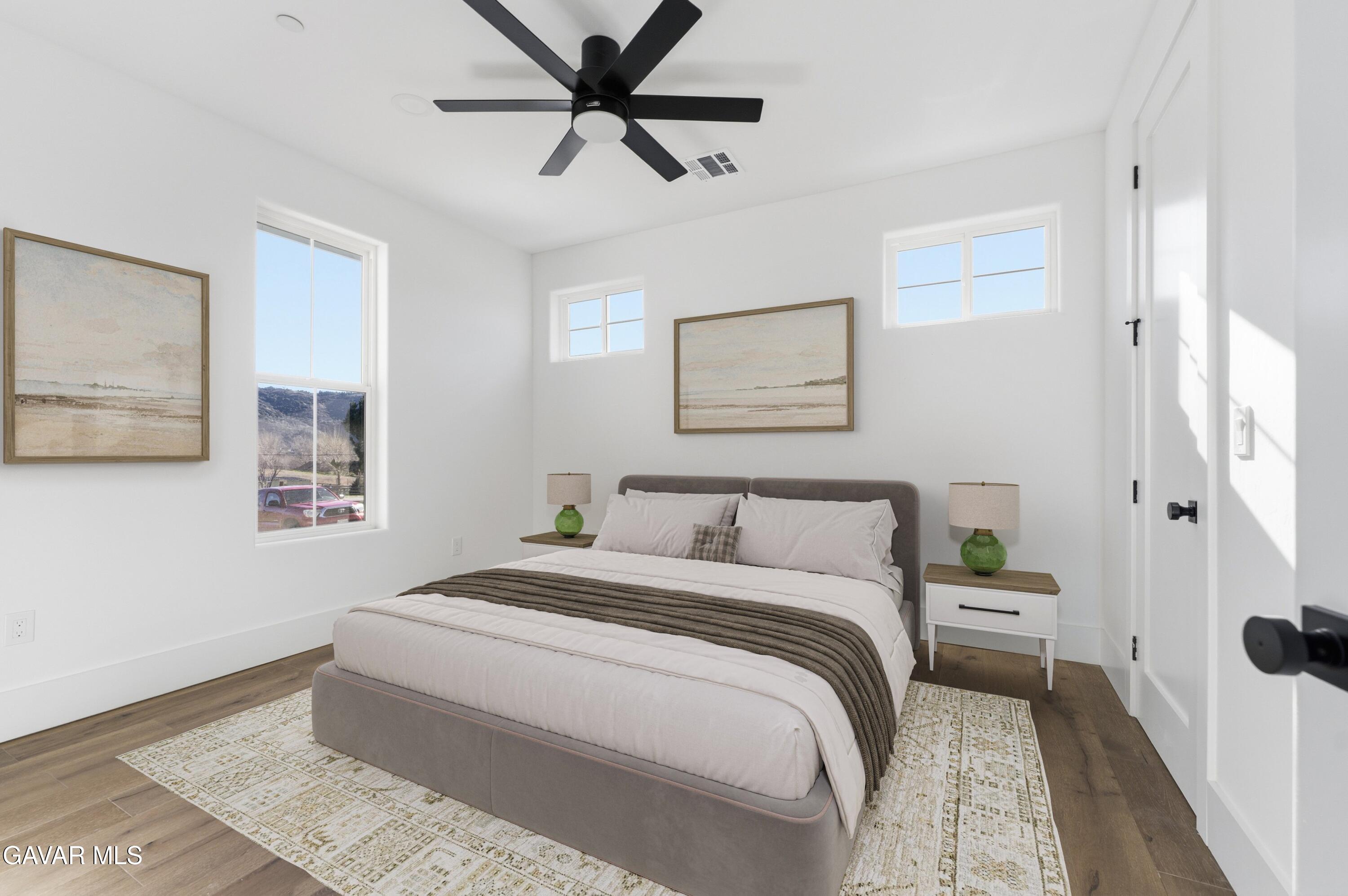 24401 Oaktree Court Tehachapi, CA 93561 - Photo 25 of 36 a bedroom with a large bed and a chandelier