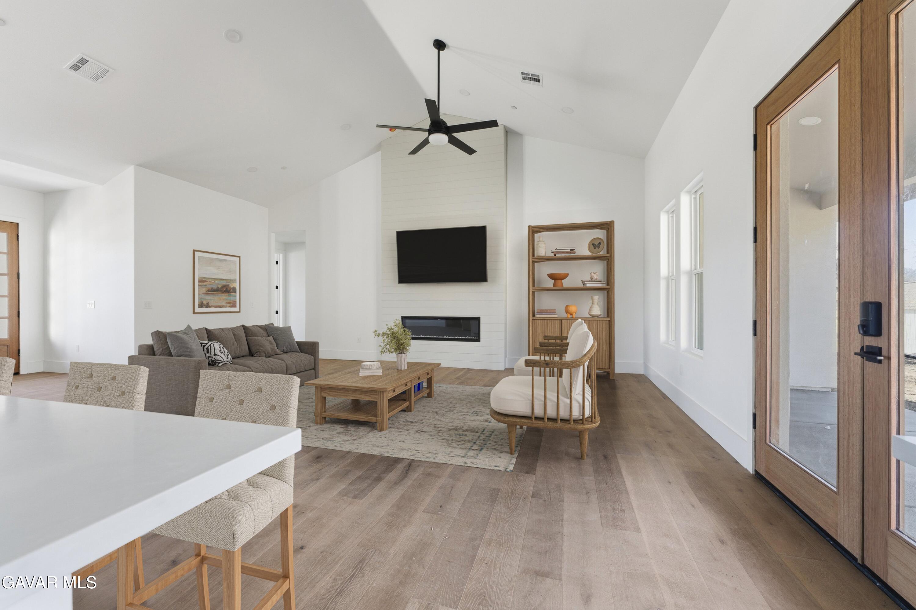 24401 Oaktree Court Tehachapi, CA 93561 - Photo 10 of 36 a living room with furniture a fireplace and a flat screen tv