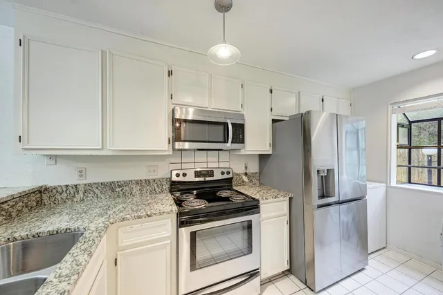 a kitchen with stainless steel appliances granite countertop a stove a refrigerator and a granite counter tops