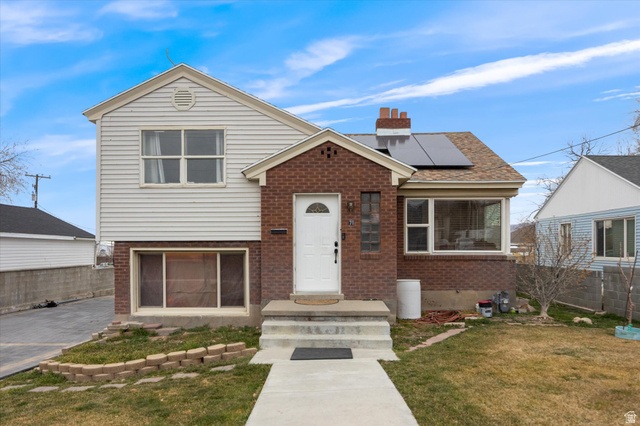 Undisclosed Address Tooele, UT 84074 - Photo 1 of 1 View of front of property with solar panels, brick siding, and a chimney