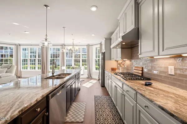 a kitchen with granite countertop a sink a counter space appliances and cabinets