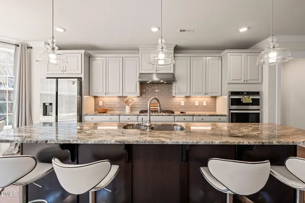 a large kitchen with a table and chairs