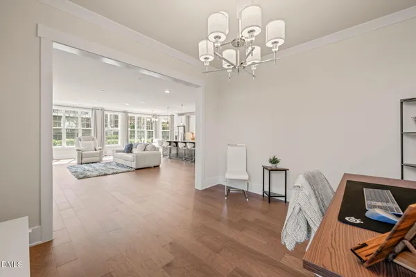 a view of a room with wooden floor lounge chair and windows