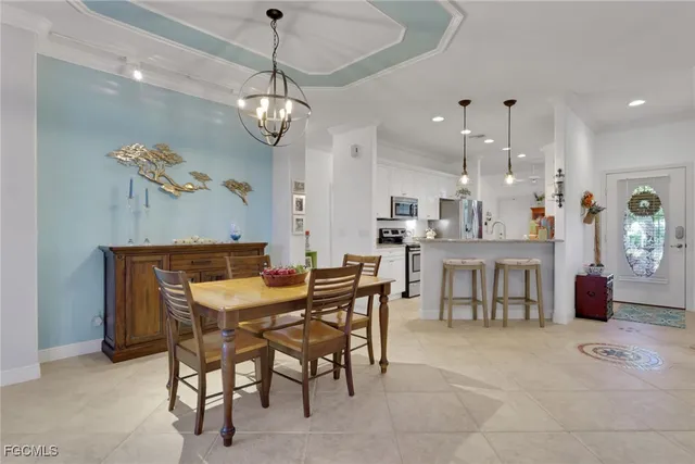 a view of a dining room and livingroom with furniture wooden floor a chandelier