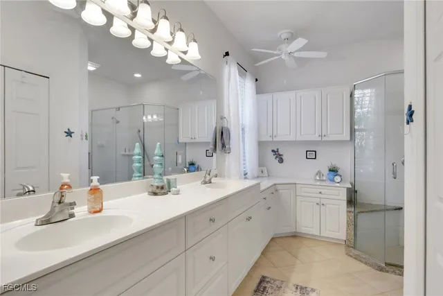 a view of a double sink and chandelier