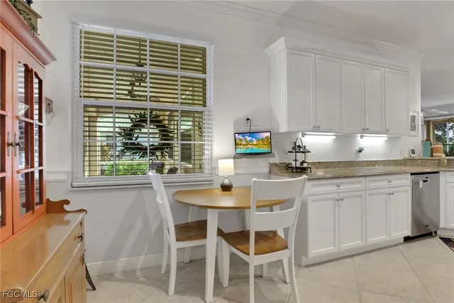 a kitchen with stainless steel appliances kitchen island granite countertop white cabinets and a stove top oven