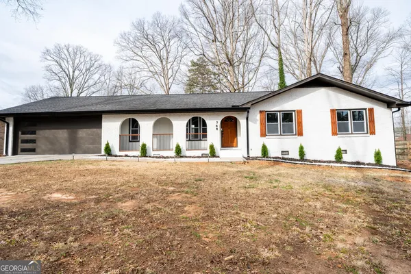a front view of house with yard and trees around