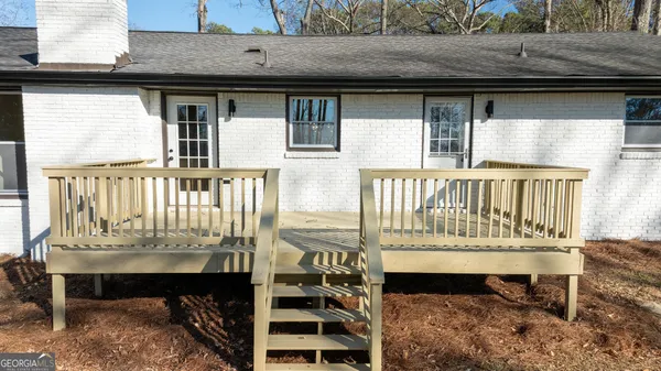 a view of a house with wooden deck and furniture