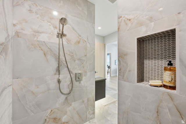 2002 East Outlaw Road Kamas, UT 84036 - Photo 58 of 65 Spacious shower enclosure featuring large-format veined wall tiles, a built-in niche with mosaic tile backing, and a brushed nickel showerhead with a handheld sprayer