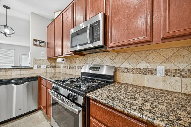 a kitchen with stainless steel appliances granite countertop a stove and a microwave