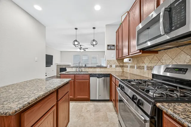 a kitchen with stainless steel appliances granite countertop a stove and a sink