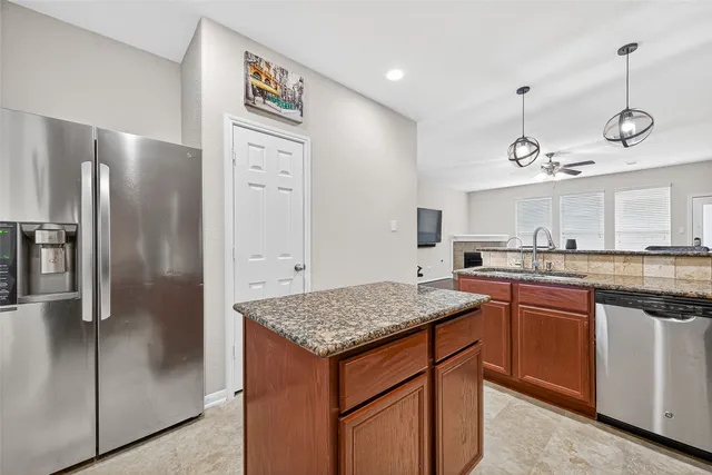 a kitchen with stainless steel appliances granite countertop a sink and dishwasher refrigerator a granite counter top