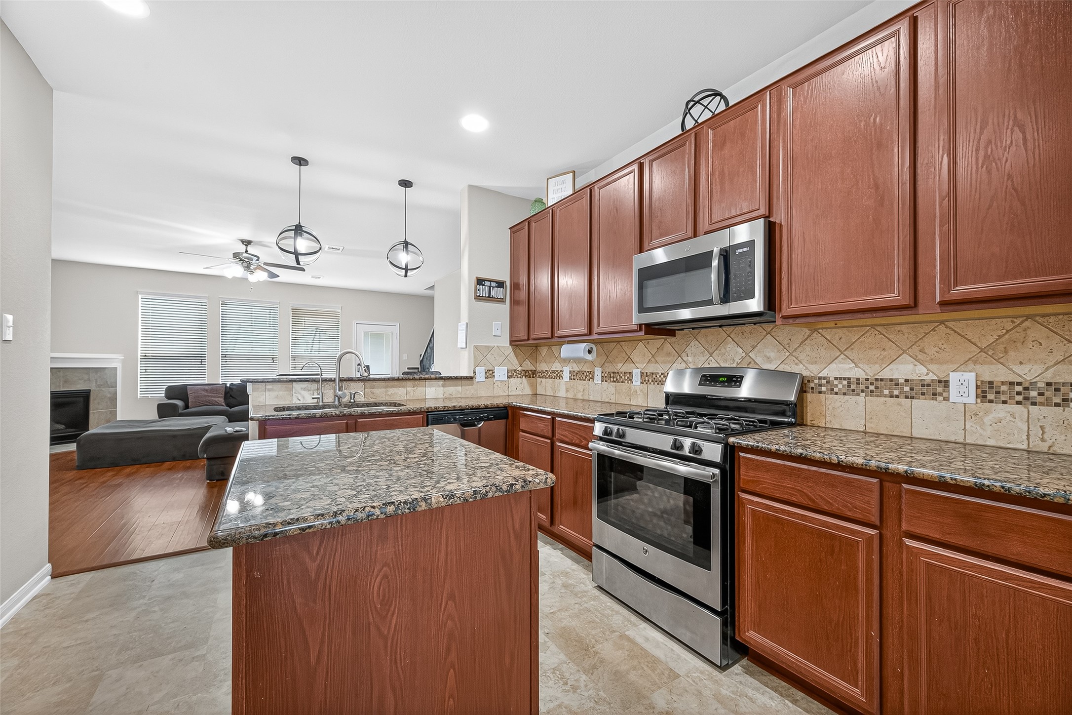 2611 Cottage Step Trail Fresno, TX 77545 - Photo 19 of 48 a kitchen with stainless steel appliances granite countertop a stove a sink and a microwave