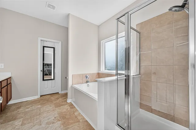 a bathroom with a tub a sink and mirrors
