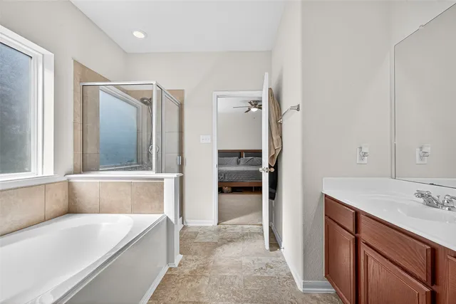 a bathroom with a tub sink and mirror
