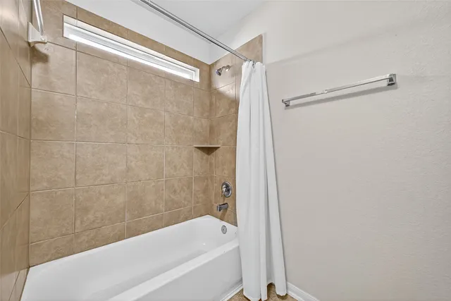 a bathroom with a shower and a bath tub