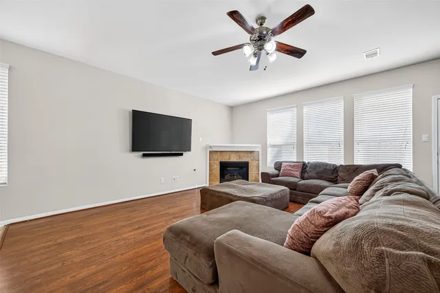 a living room with furniture ceiling fan and a flat screen tv