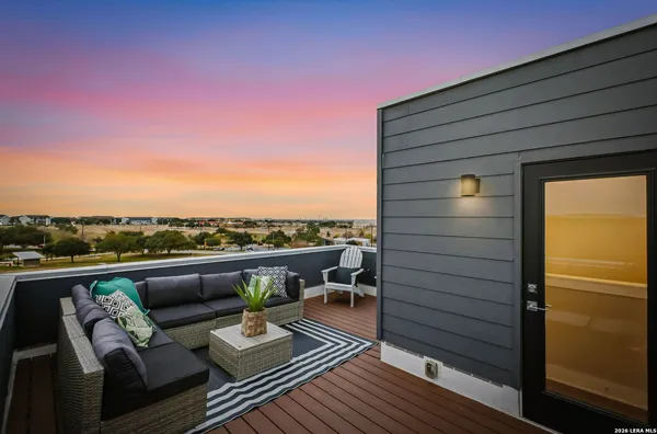 a view of roof deck with couches and wooden floor