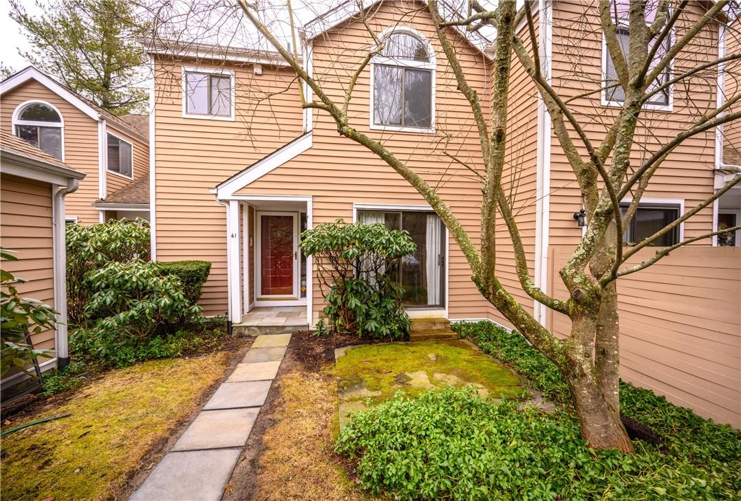 a view of house with a yard and potted plants