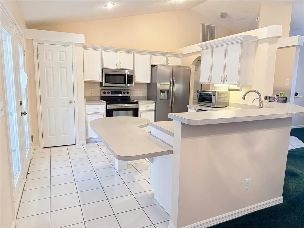 4262 Northeast 35th Avenue Road Ocala, FL 34479 - Photo 11 of 28 a kitchen with stainless steel appliances a sink a stove a microwave and a refrigerator