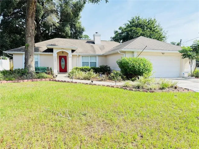 a front view of a house with yard and trees