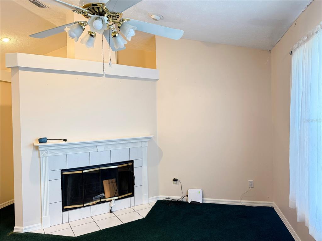 4262 Northeast 35th Avenue Road Ocala, FL 34479 - Photo 4 of 28 a room with a fireplace and a ceiling fan