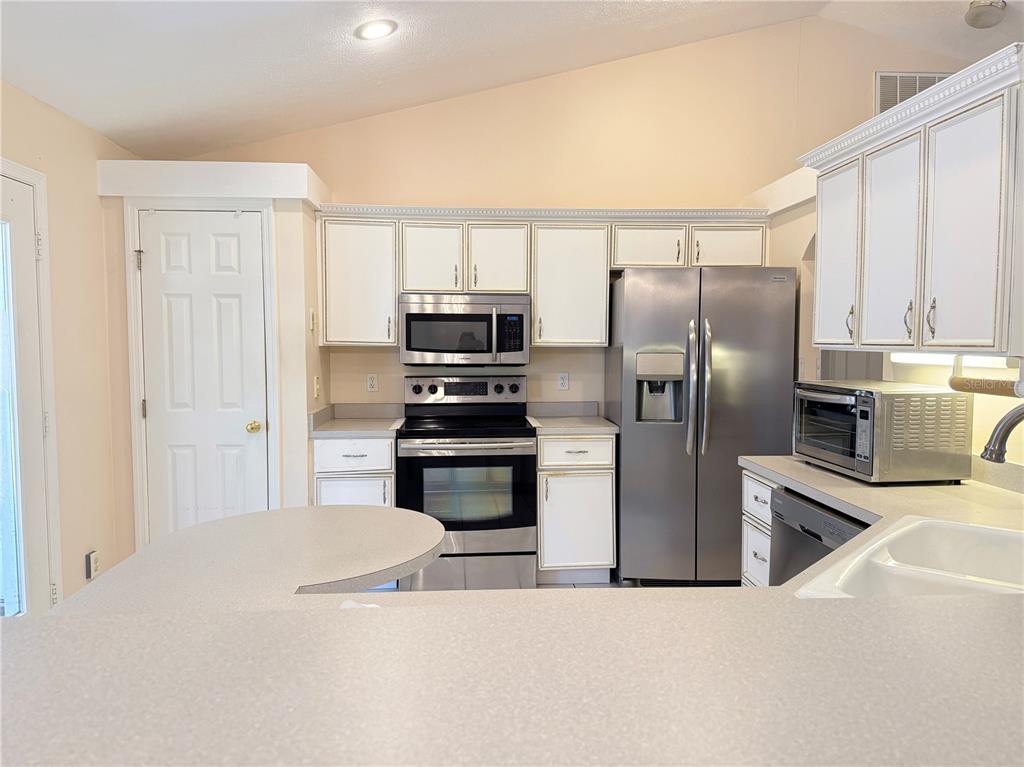 4262 Northeast 35th Avenue Road Ocala, FL 34479 - Photo 8 of 28 a kitchen with stainless steel appliances a refrigerator and a stove top oven