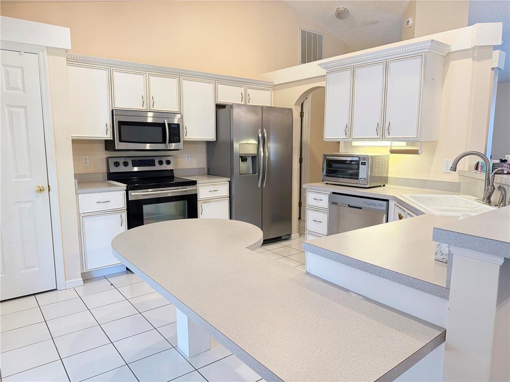 4262 Northeast 35th Avenue Road Ocala, FL 34479 - Photo 9 of 28 a kitchen with stainless steel appliances a refrigerator stove microwave and sink
