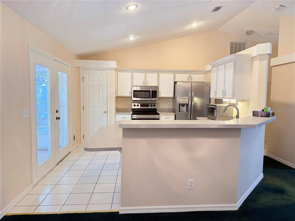 4262 Northeast 35th Avenue Road Ocala, FL 34479 - Photo 10 of 28 a kitchen with stainless steel appliances a refrigerator and a stove top oven