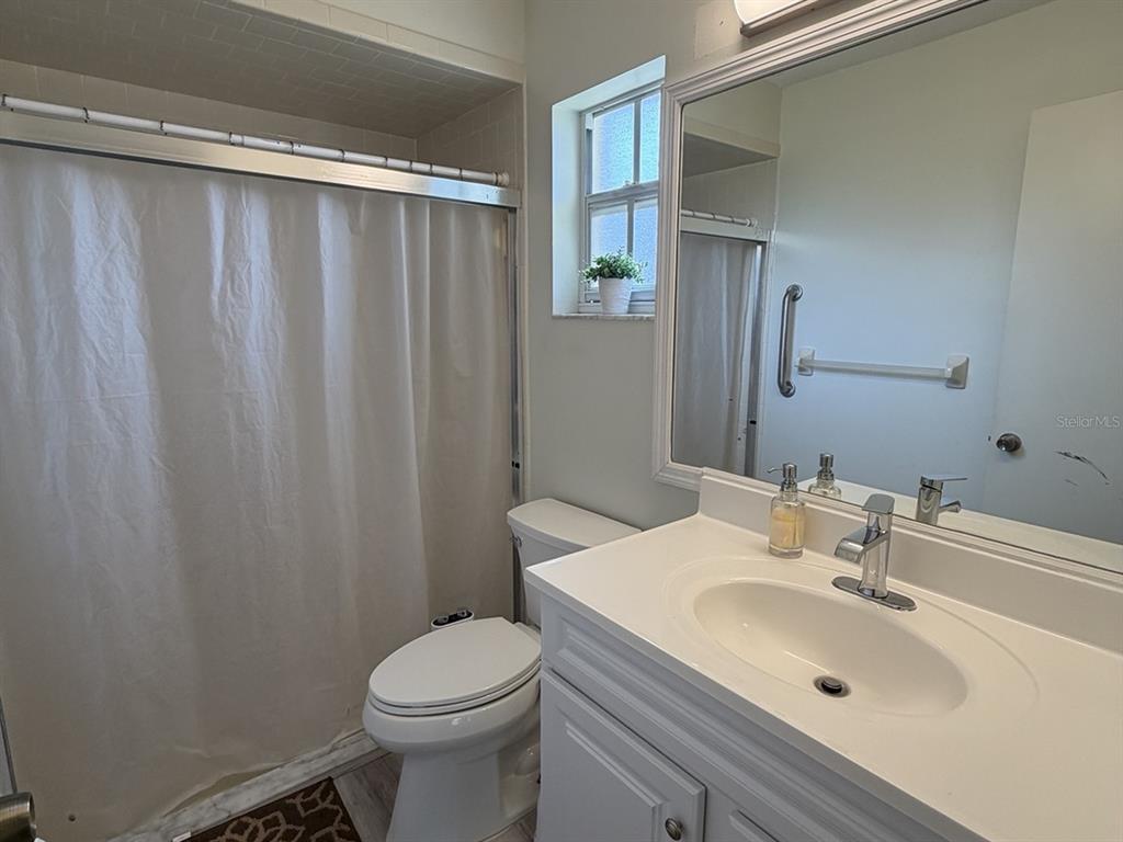 1629 Willow Run Sebring, FL 33872 - Photo 7 of 16 a bathroom with a sink a toilet and shower curtain