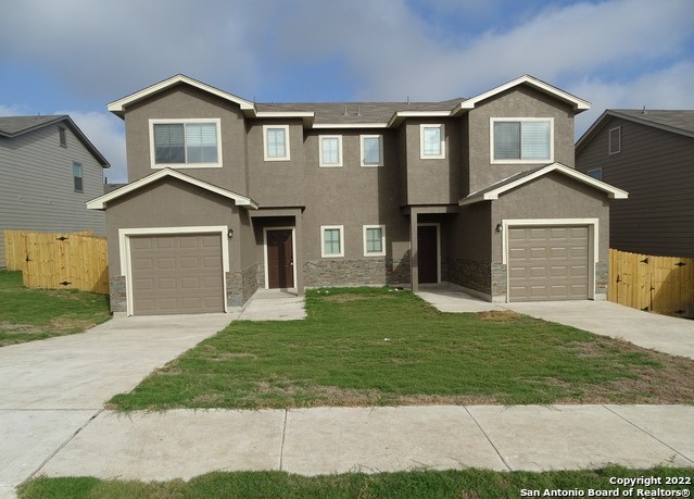 a front view of a house with a yard and garage