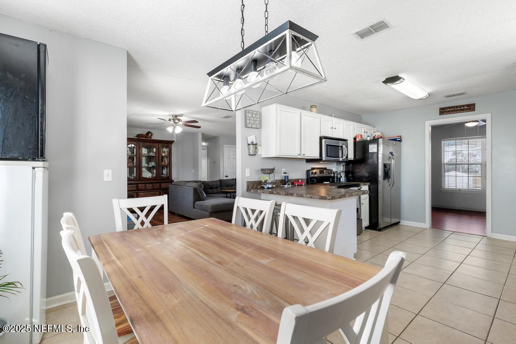 54170 Church Road Callahan, FL 32011 - Photo 23 of 44 a kitchen with a table chairs microwave and refrigerator