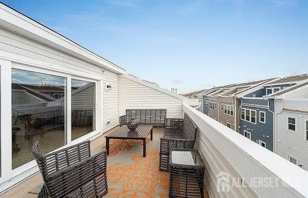 a view of a balcony with dining table and chairs with wooden floor and fence