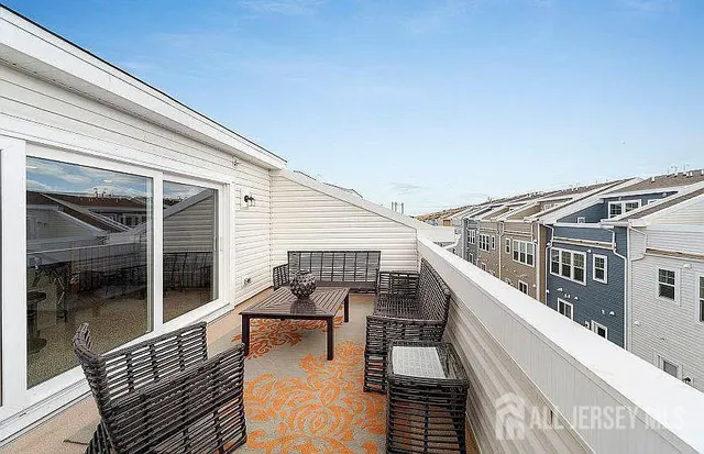 a view of a balcony with dining table and chairs with wooden floor and fence