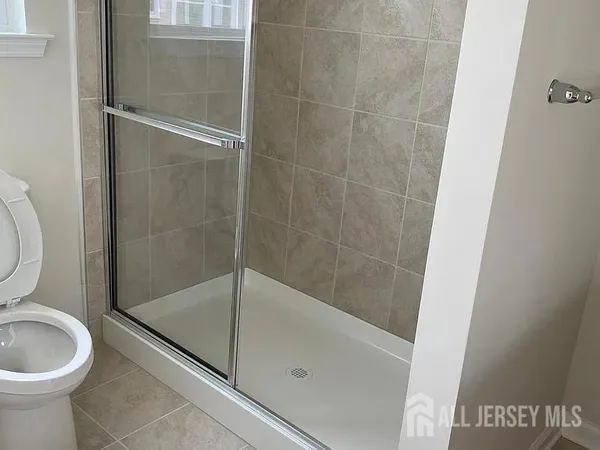 a bathroom with a granite countertop bathtub shower and toilet