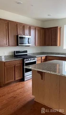 a kitchen with stainless steel appliances granite countertop a stove a sink and a microwave