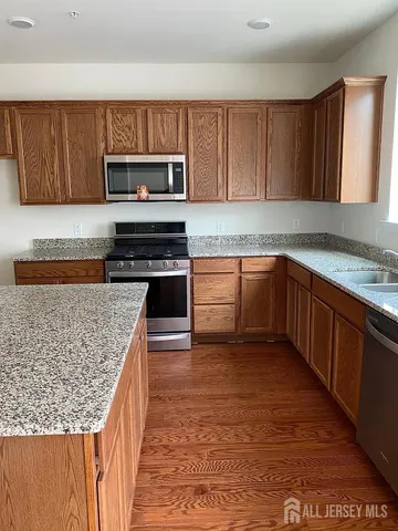 a kitchen with stainless steel appliances granite countertop a stove a sink and a microwave
