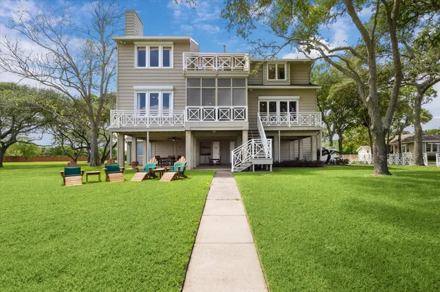 a front view of a house with a garden and trees