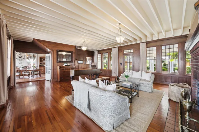 a living room with furniture floor to ceiling window and wooden floor