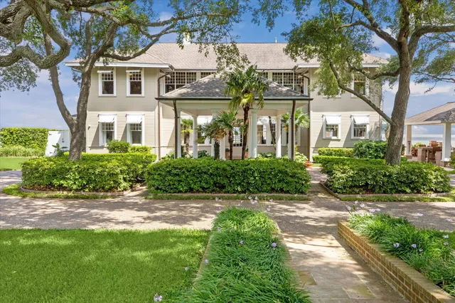 a front view of a house with a yard and shrubs