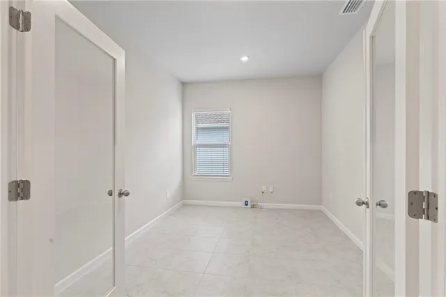 an empty room with a fan & a window