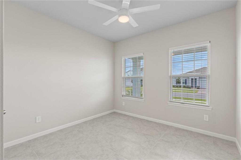 6710 Rumine Circle Vero Beach, FL 32967 - Photo 22 of 28 an empty room with chandelier fan and windows