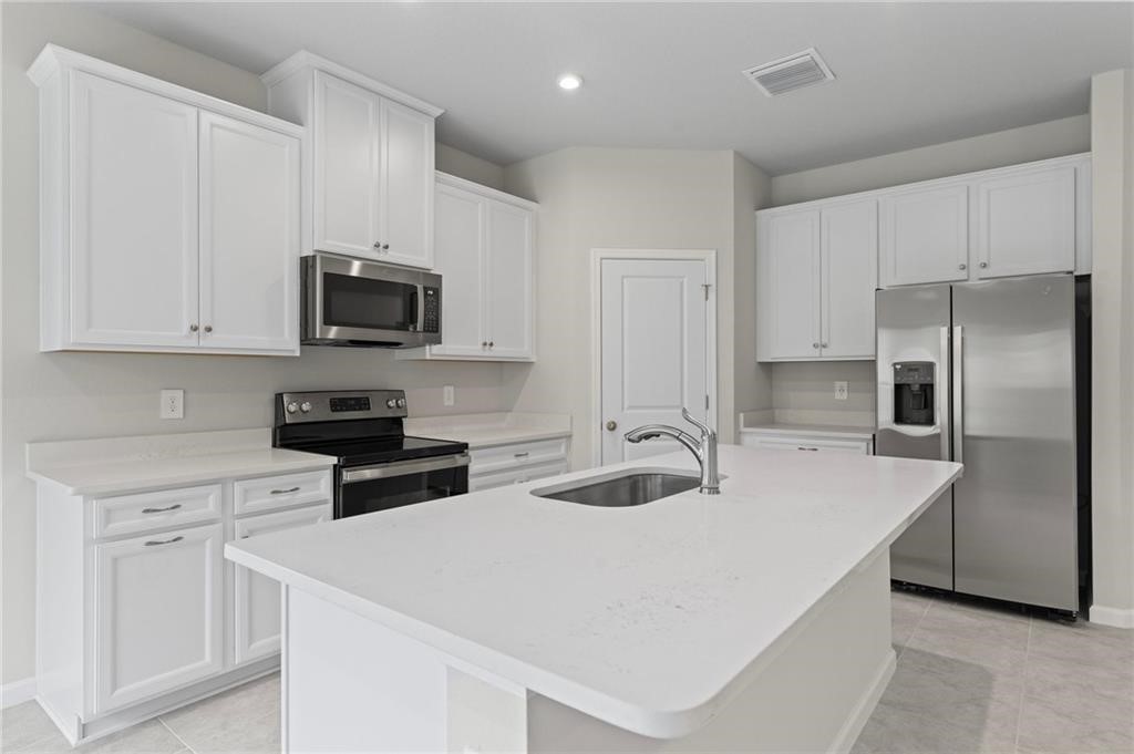 6710 Rumine Circle Vero Beach, FL 32967 - Photo 8 of 28 a kitchen with appliances a sink and cabinets