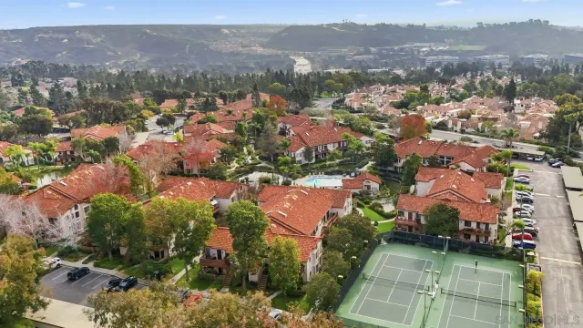 an aerial view of residential houses with outdoor space and parking