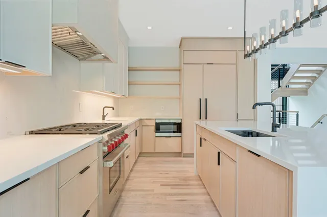 a view of a kitchen with wooden floor and electronic appliances