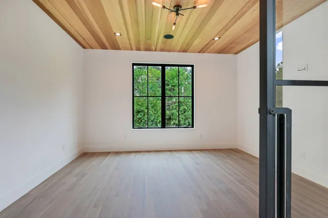 a view of a room with wooden floor and windows