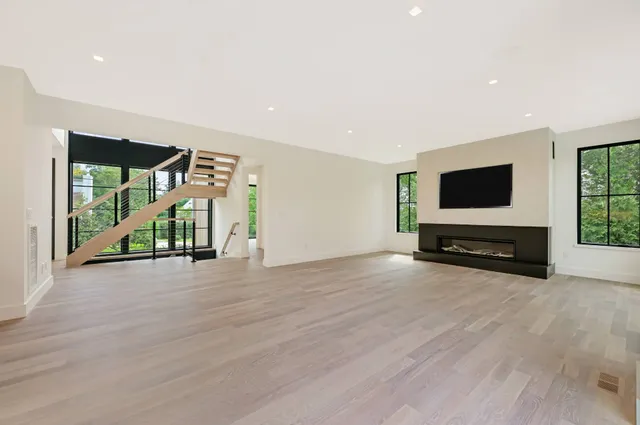 a view of a kitchen with kitchen island a sink wooden floor and living room