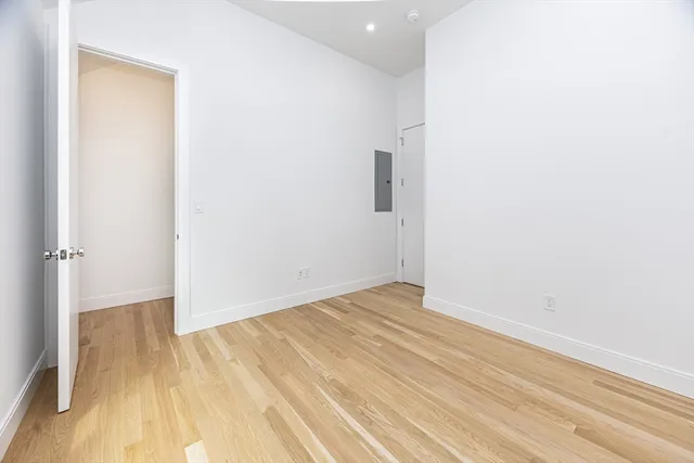 a view of empty room with wooden floor