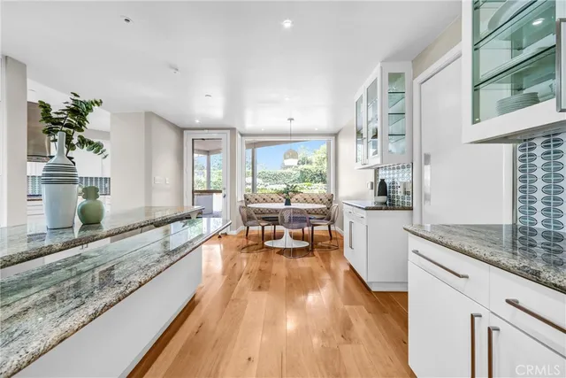 a large living room with stainless steel appliances granite countertop wooden floor and a large window