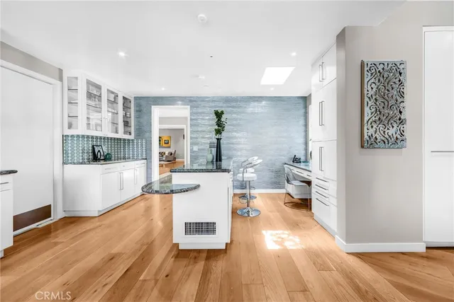 a living room with stainless steel appliances furniture a rug and a kitchen view